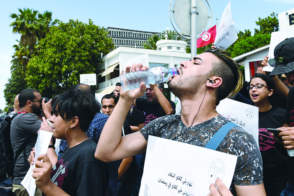 TUNIS:  In this file photo, a Tunisian man drinks water during a demonstration in Tunis to denounce the arrests of non-fasting people during the Muslim fasting month. - AFP