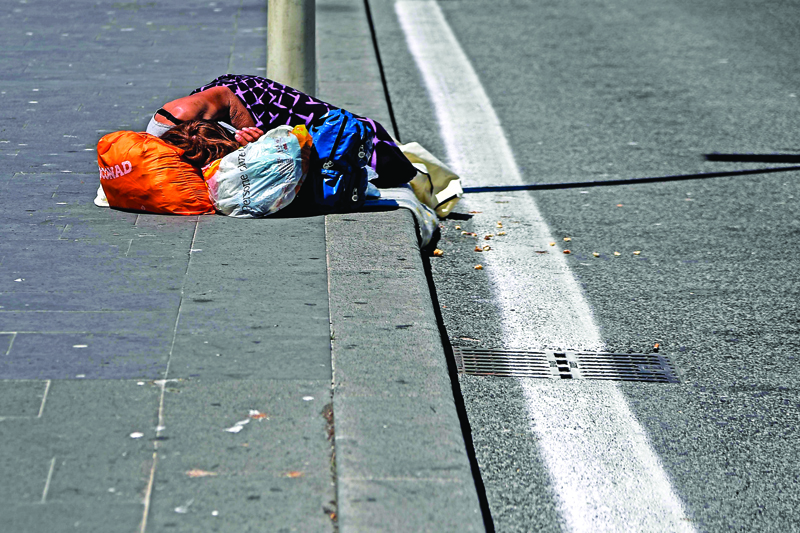 A homeless woman sleeps on the pavement on May 4, 2020 outside the Termini railway in Rome, as Italy starts to ease its lockdown, during the country's lockdown aimed at curbing the spread of the COVID-19 infection, caused by the novel coronavirus. - Stir-crazy Italians will be free to stroll and visit relatives for the first time in nine weeks on May 4, 2020 as Europe's hardest-hit country eases back the world's longest nationwide coronavirus lockdown. (Photo by Filippo MONTEFORTE / AFP)