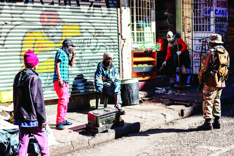 A South African National Defence Force (SANDF) soldier commands a man to wear a face mask in Hillbrow, Johannesburg, on May 1, 2020, during a joint patrol by the South African National Defence Force (SANDF), the South African Police Service (SAPS) and the Johannesburg Metro Police Department (JMPD). - South Africa began to gradually loosen its strict COVID-19 coronavirus lockdown on May 1, 2020, after five weeks of restrictions. (Photo by Michele Spatari / AFP)