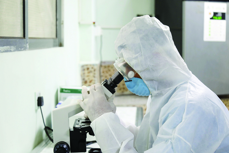 An employee, wearing his personal protective equipment (PPE), looks through a microscope at the newly-inaugurated laboratory for coronavirus testing in Yemen's third city of Taiz, on April 30, 2020. - Yemen's healthcare system has been blighted by years of war that have driven millions from their homes and plunged the country into what the United Nations describes as the world's worst humanitarian crisis. (Photo by AHMAD AL-BASHA / AFP)