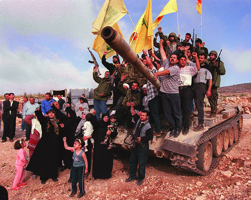 MARJAYOUN, Lebanon: In this file photo taken on May 24, 2000, Lebanese and Hezbollah fighters pose for a picture on and around a tank abandoned by the Israeli-allied South Lebanon Army (SLA) militia in this southern town, which was the headquarters of SLA and the Israeli occupation troops. – AFP