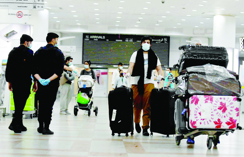Kuwaiti nationals arrive at the Kuwait International Airport, south of the capital Kuwait City, after a rapatriation plan for citizens stranded abroad was put together by the authorities, on May 3, 2020, during the novel coronavirus pandemic crisis. - All incoming citizens will be required to undergo home quarantine for 14 consecutive days. (Photo by YASSER AL-ZAYYAT / AFP)