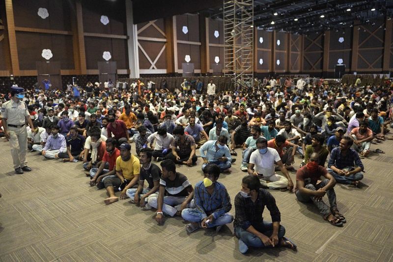 Stranded migrant workers sit in a waiting hall before registering with police officials for a movement pass to be able to return to their hometowns after the government eased a nationwide lockdown imposed as a preventive measure against the COVID-19 coronavirus, on the outskirts of Hyderabad on May 5, 2020. (Photo by NOAH SEELAM / AFP)