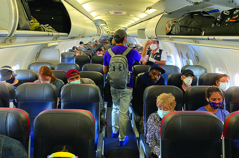 NEW YORK: Passengers, almost all wearing facemasks, board an American Airlines flight to Charlotte on May 3, 2020. – AFP