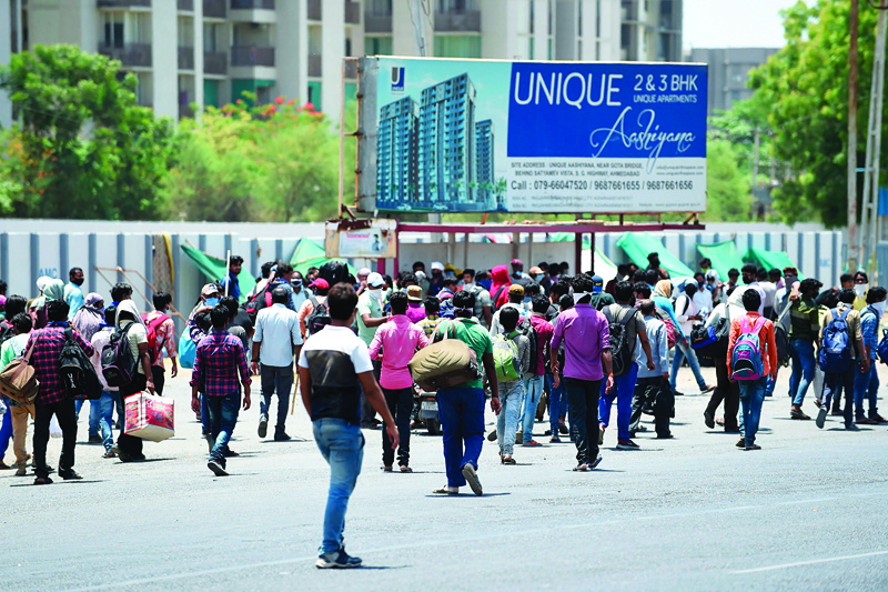 Stranded migrant workers intending to go to their hometowns, leave Gota Bridge area as Gujarat Police personnel (unseen) shoove them away during a government-imposed nationwide lockdown as a preventive measure against the spread of the COVID-19 coronavirus on the outskirts of  Ahmedabad on May 8, 2020. (Photo by SAM PANTHAKY / AFP)