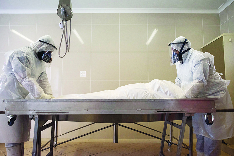 CAPE TOWN: Members of a Muslim burial organisation prepare the body of a man who died of COVID-19 coronavirus for burial, at the Ghietmatiel Islamia Mosque in Athlone, Cape Town. — AFP