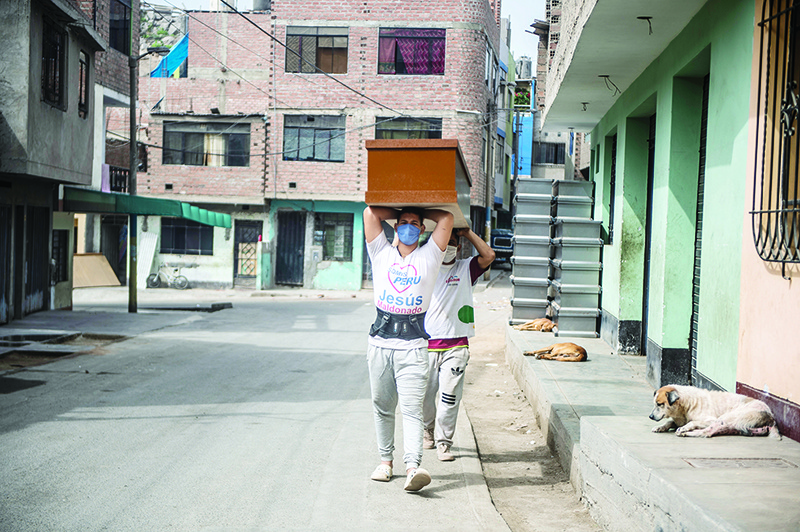 LIMA: Workers carry a coffin made of Mapresa (pressed wood) to be stored at a factory at Juan de Lurigancho district in Lima amid the COVID-19 coronavirus pandemic. — AFP