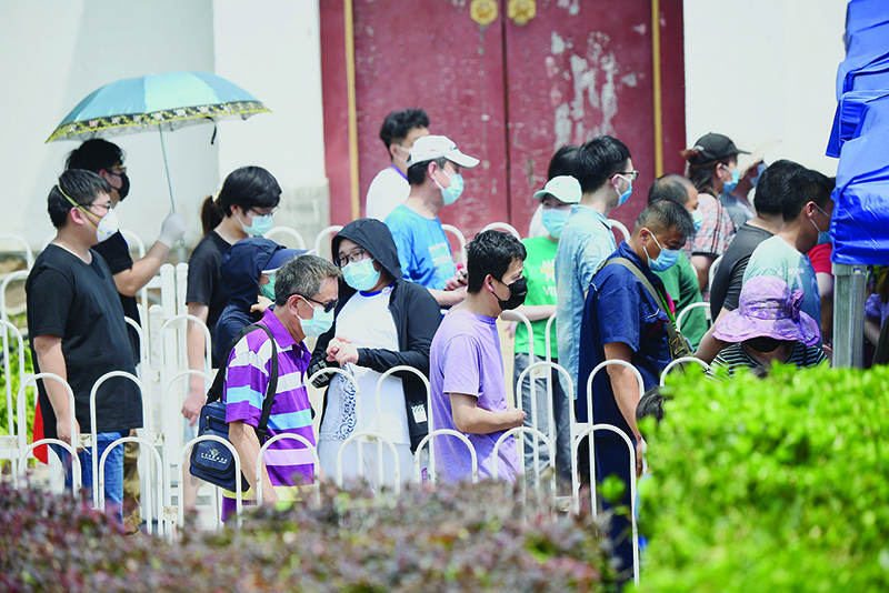BEIJING: People wearing face masks queue for swab tests, for those who are living or visited the Xinfadi Market, in Beijing yesterday. — AFP
