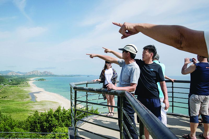 GOSEONG: Visitors (standing at the Goseong observatory before the Demilitarized Zone) look towards North Korea (background) from Goseong. — AFP