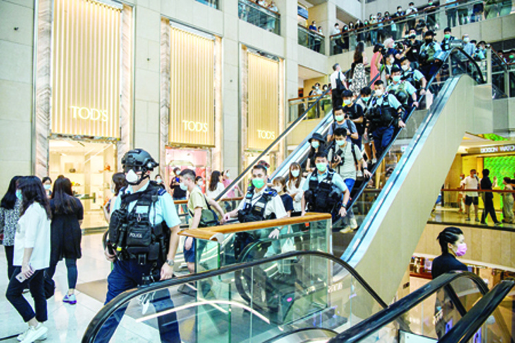 Police enter a shopping mall to disperse people attending a lunchtime rally in Hong Kong on June 30, 2020, as China passed a sweeping national security law for the city. - China passed a sweeping national security law for Hong Kong, a historic move that critics and many western governments fear will smother the finance hub's freedoms and hollow out its autonomy. (Photo by Anthony WALLACE / AFP)