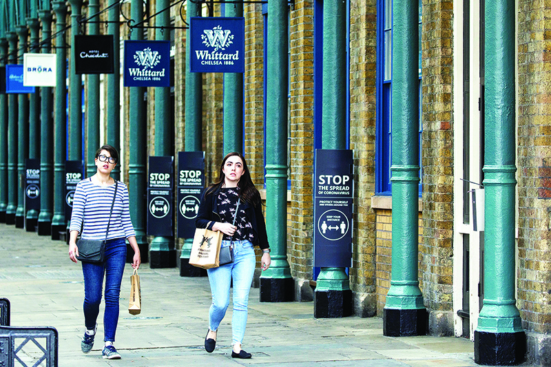 LONDON: Shoppers walk past signs asking people to adhere to the British government’s current social distancing guidelines and stay two meters (2M) apart, as they pass re-opened shops, originally made to close down during the COVID-19 lockdown in Covent Garden in London.—Reuters