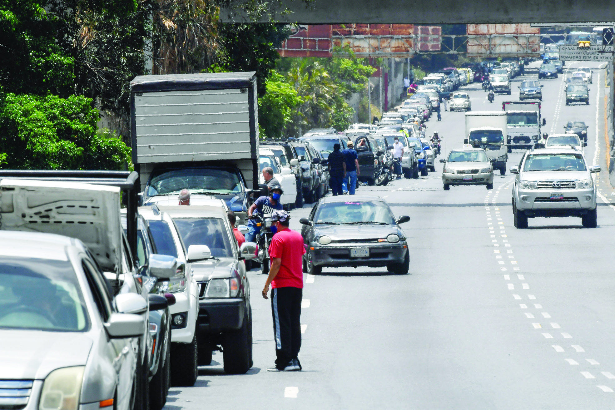 CARACAS: Drivers queue to refuel the tanks of their cars near a gas station, in Caracas on Wednesday. Falling fossil fuel demand coupled with mounting risk for investors could slash the value of oil, gas and coal reserves by two thirds, energy analysts warned yesterday. — AFP