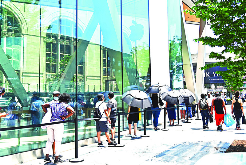 NEW YORK CITY: People wait in line outside an Apple store on Monday in the Brooklyn Borough of New York City. Apple Inc on Monday said it will switch to its own chips for its Mac computers, saying the first machines will ship this year.—AFP