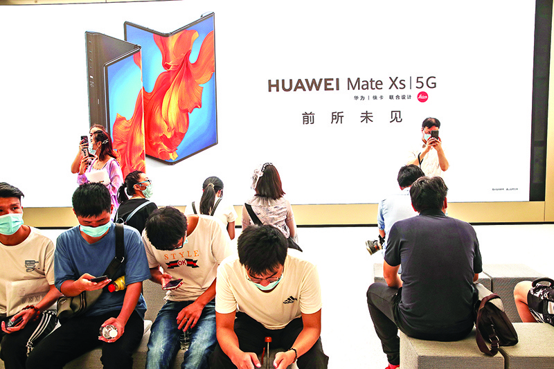 SHANGHAI: People rest at a newly-opened Huawei global flagship store in Shanghai. With growing pressure to keep China’s Huawei out of 5G network development, it could be time for firms like Japan’s NEC and South Korea’s Samsung to shine. – AFP
