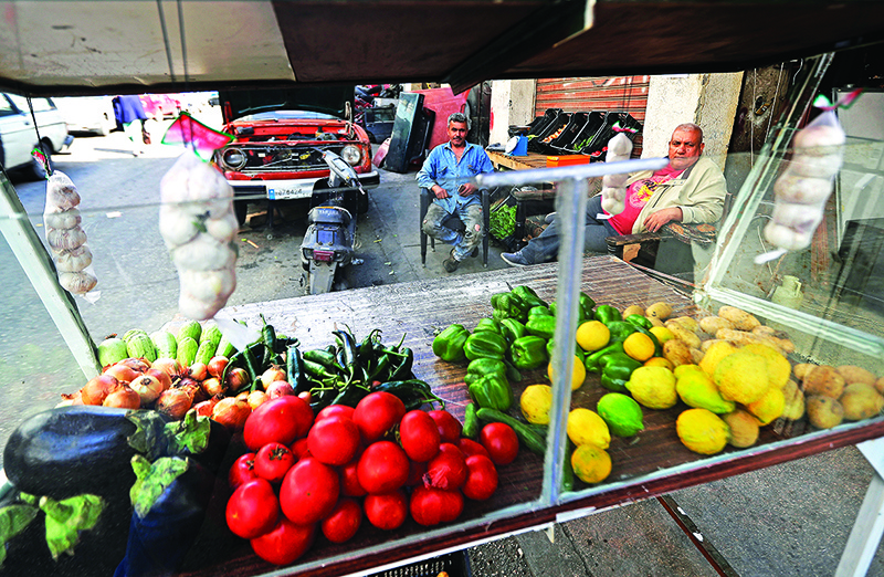 TRIPOLI: A grocer sits near produce outside his shop in the Bab al-Tabbaneh neighborhood of Lebanon’s northern city of Tripoli. – AFP