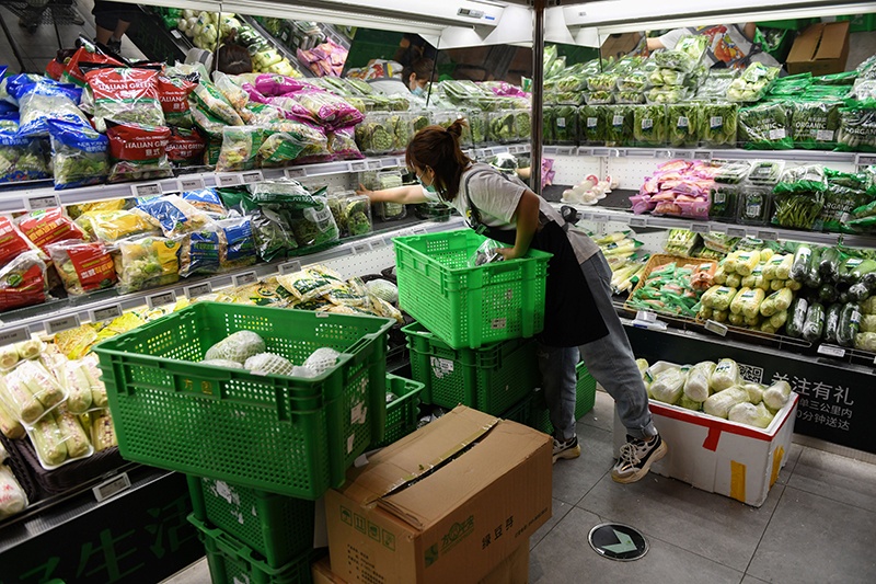 BEIJING: A worker stocks shelves in the vegetables section of a supermarket in Beijing yesterday. The supermarket, which has its own supply chain not linked to the Xinfadi market, has seen a 20 percent increase in online orders since a new outbreak of the COVID-19 coronavirus in Beijing last week. — AFP