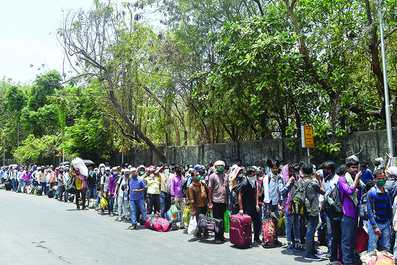 Migrant workers queue outside the Chhatrapati Shivaji Maharaj Terminus railway station to return to their hometowns after the government eased a nationwide lockdown as a preventive measure against the COVID-19 coronavirus, in Mumbai on May 19, 2020. - The lockdown affecting 1.3 billion people-the worldís largest-has been in force since late March and has been devastating for Indiaís poor with millions of migrant workers losing their jobs. (Photo by PUNIT PARANJPE / AFP)