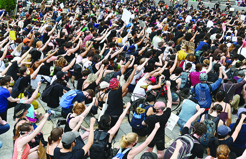 NEW YORK: Protesters take a knee and raise their fists during a ‘Black Lives Matter’ demonstration in front of the Brooklyn Library and Grand Army Plaza on June 5, 2020 in Brooklyn, New York, amid ongoing protests over the death in police custody of George Floyd. — AFP