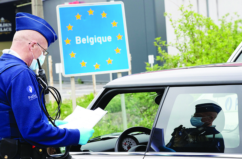 QUEVY: A Belgian Police officer controls the documents of a person in a car at the border between Belgium and France during a police patrol in Quevy. — AFP