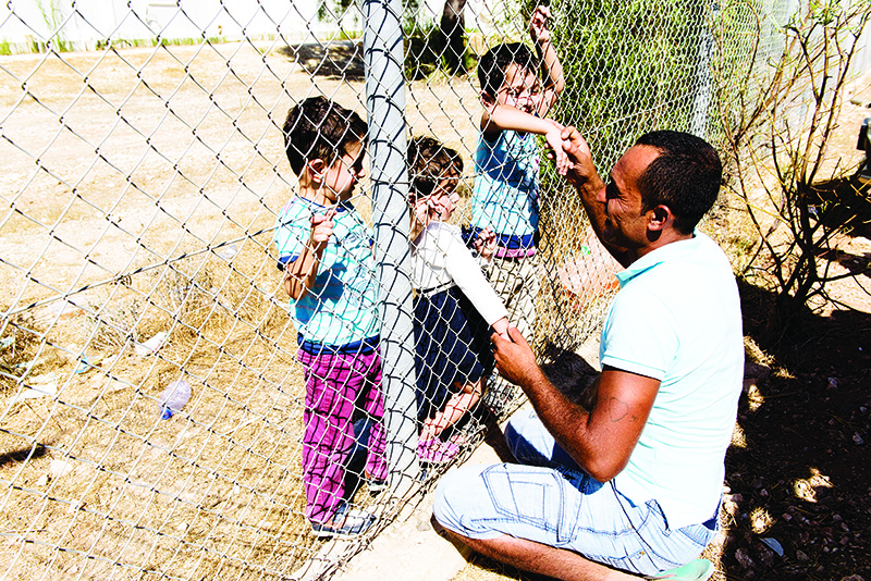 KOKKINOTRIMITHIA: In this file photo, Syrian refugee Ammar Hammasho, greets his children from which he was seperated due to the conflict, as they are reunite at the Kokkinotrimithia refugee camp, some 20 kilometres outside the Cypriot capital Nicosia. — AFP