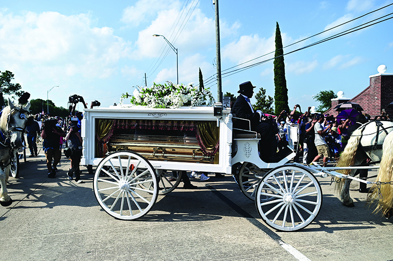 HOUSTON: People watch as a horse-drawn hearse containing the remains of George Floyd passes by during a funeral procession on Tuesday. — AFP