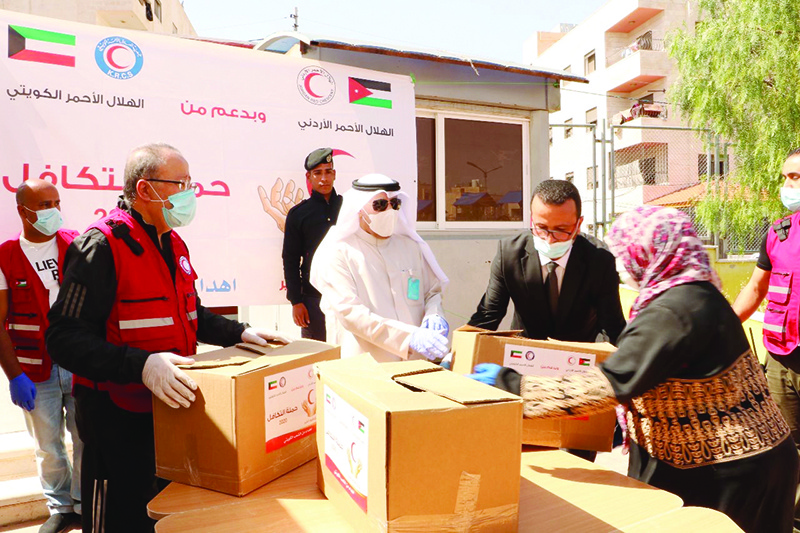 AMMAN: This May 29, 2020 file photo shows relief workers preparing food parcels donated by the Kuwait Red Crescent Society to Syrian refugees in Amman, Jordan. — KUNA