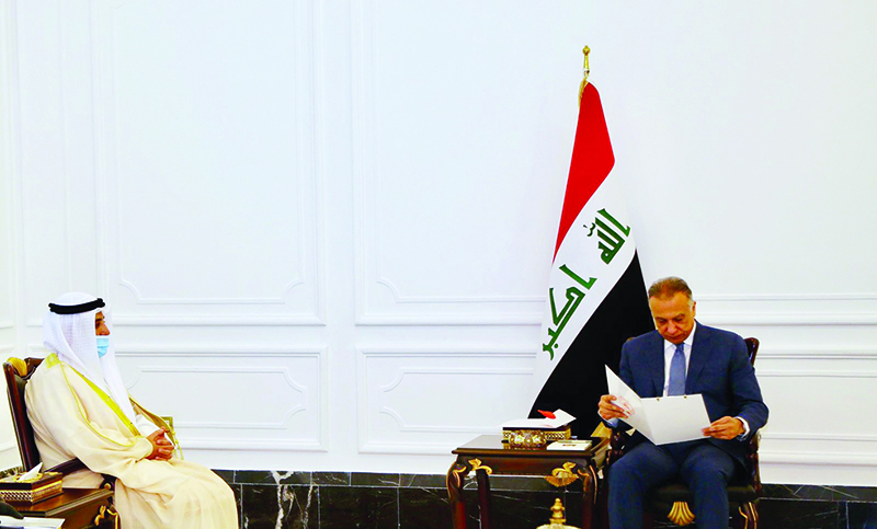 Iraqi Prime Minister Mustafa Al-Kadhimi reads a letter from His Highness the Amir Sheikh Sabah Al-Ahmad Al-Jaber Al-Sabah, during his meeting with Kuwaiti Foreign Minister Sheikh Dr Ahmad Nasser Al-Mohammad Al-Sabah. - KUNA