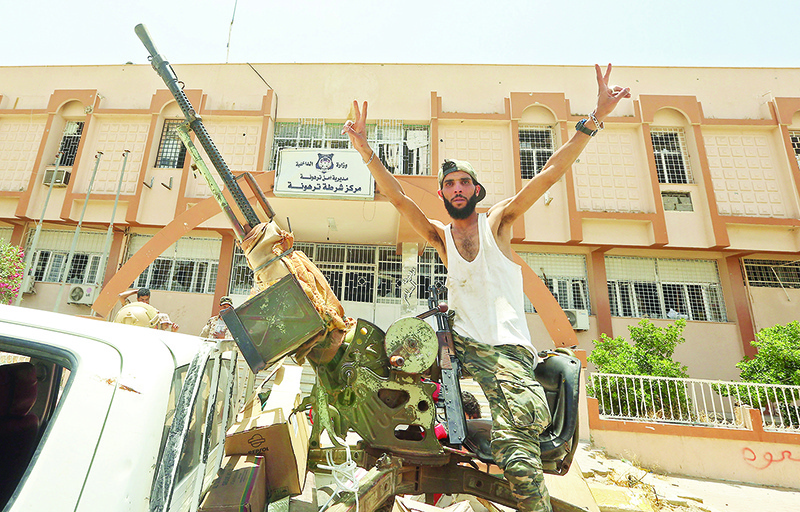 TRIPOLI: A fighter loyal to Libya’s UN-recognised Government of National Accord (GNA) poses for a picture while seated in the turret a technical (pickup truck mounted with turret) in the town of Tarhuna. — AFP