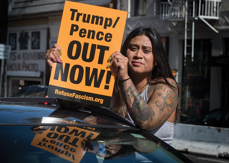 A protester holds a sign as she demonstrates against the President Trump and Vice President Pence White House at Trump's Hollywood Walk of Fame star in Hollywood, California on June 20, 2020. (Photo by Mark RALSTON / AFP)