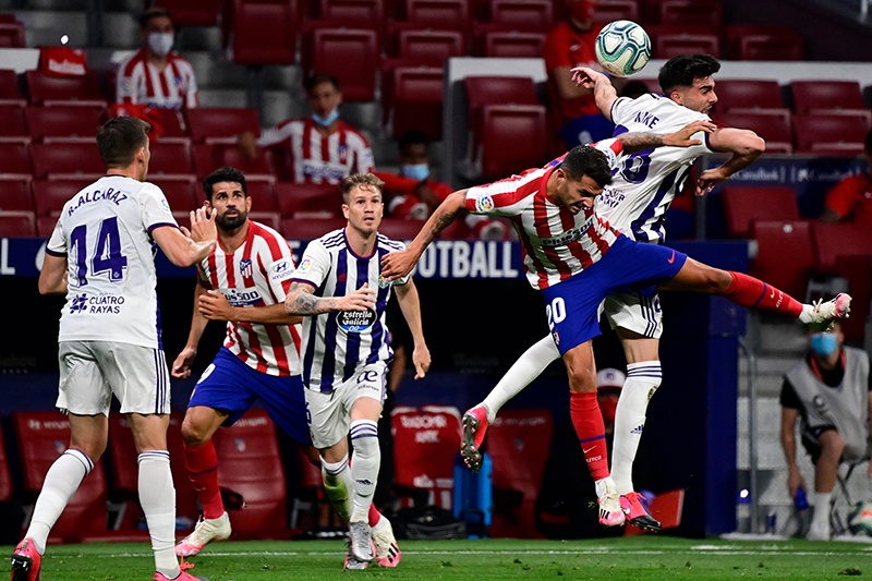 MADRID: Valladolid´s Spanish midfielder Kike Perez (R) and Atletico Madrid’s Spanish midfielder Vitolo jump for the ball during the Spanish League football match between Atletico Madrid and Real Valladolid at the Wanda Metropolitan stadium in Madrid on June 20, 2020. — AFP