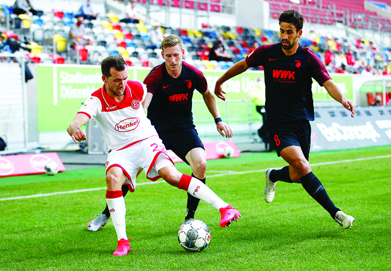 DUESSELDORF: File photo shows Fortuna Dusseldorf’s Kevin Stoger vies with FC Augsburg’s Andre Hahn and Rani Khedira during the German first division Bundesliga football match Fortuna Duesseldorf v FC Augsburg on June 20, 2020 in Duesseldorf, western Germany. — AFP