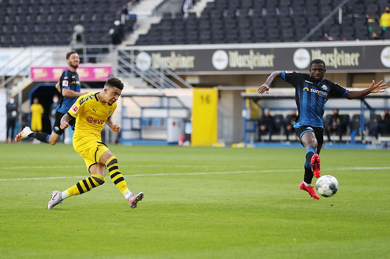 Dortmund's English midfielder Jadon Sancho scores his teams sixth goal past Paderborn's German goalkeeper Leopold Zingerle during the German first division Bundesliga football match SC Paderborn 07 and Borussia Dortmund at Benteler Arena in Paderborn on May 31, 2020. - Dortmund's English midfielder Jadon Sancho scores his teams sixth goal past Paderborn's German goalkeeper Leopold Zingerle (Photo by Lars Baron / POOL / AFP) / DFL REGULATIONS PROHIBIT ANY USE OF PHOTOGRAPHS AS IMAGE SEQUENCES AND/OR QUASI-VIDEO