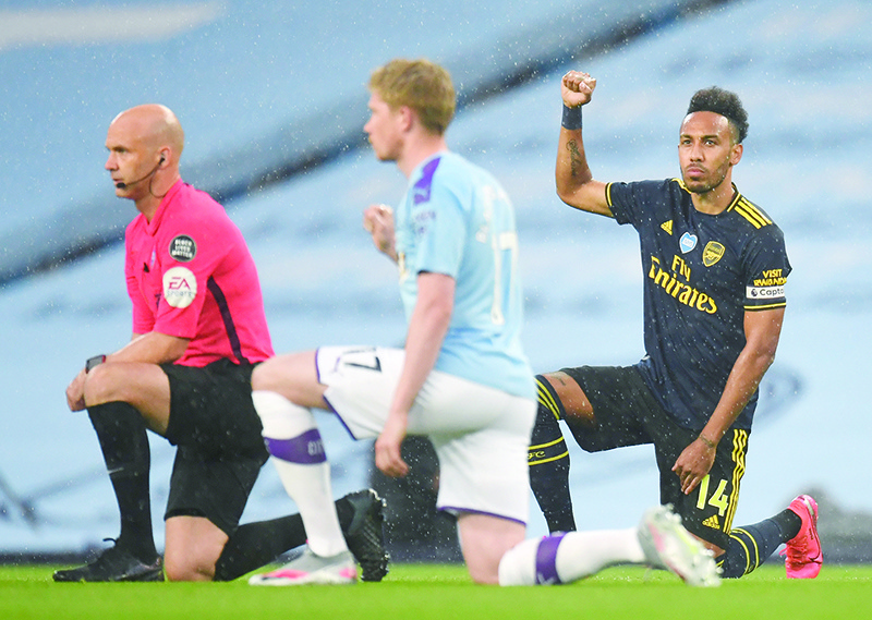 MANCHESTER: Arsenal’s Gabonese striker Pierre-Emerick Aubameyang (right) takes a knee alongside Manchester City’s Belgian midfielder Kevin De Bruyne (center) and Referee Anthony Taylor ahead of the English Premier League football match between Manchester City and Arsenal at the Etihad Stadium in Manchester, north west England, on June 17, 2020. — AFP