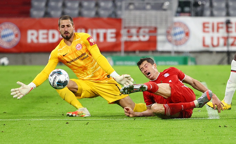 MUNICH: Bayern Munich’s Polish forward Robert Lewandowski (R) attempts to score past Frankfurt’s German goalkeeper Kevin Trapp during the German Cup (DFB Pokal) semi-final football match FC Bayern Munich v Eintracht Frankfurt in Munich, southern Germany on June 10, 2020. — AFP