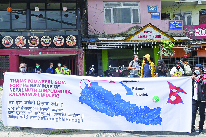 KATHMANDU: Protesters hold a banner with a new map during a demonstration against the government’s handling of the fight against the COVID-19 coronavirus, in Kathmandu. — AFP