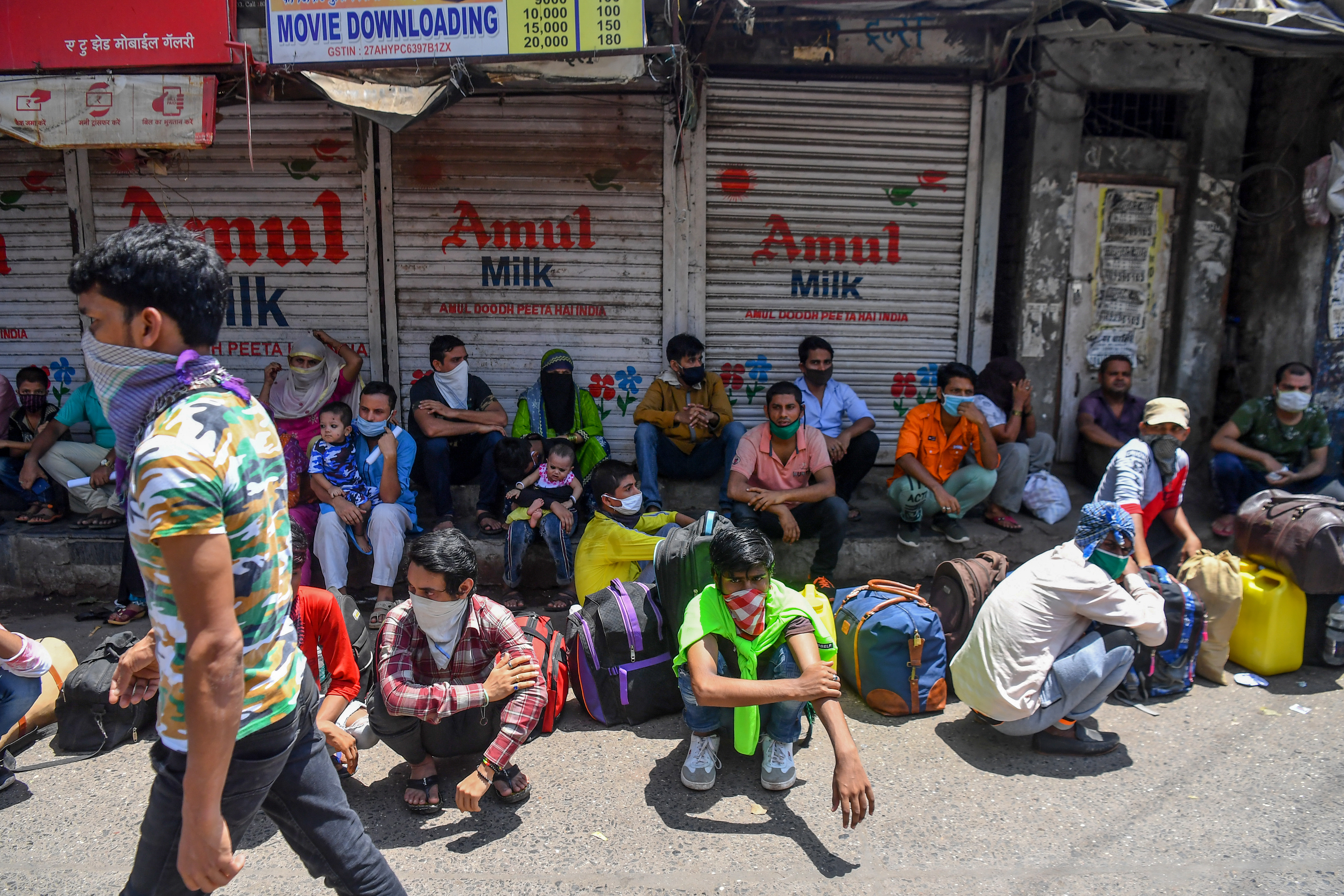 MUMBAI: Migrant workers and families wait outside Dharavi slums for transportation to a railway terminus to catch a train back home after the government eased a nationwide lockdown imposed against the COVID-19 coronavirus, in Mumbai.—AFP