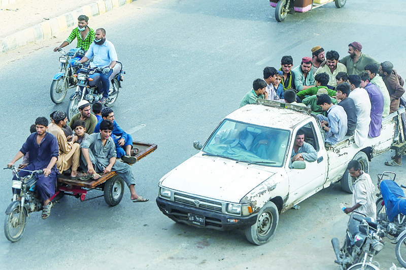 KARACHI: People gather in vehicles to travel on a street as COVID-19 coronavirus cases still increase in the country in Karachi. —AFP