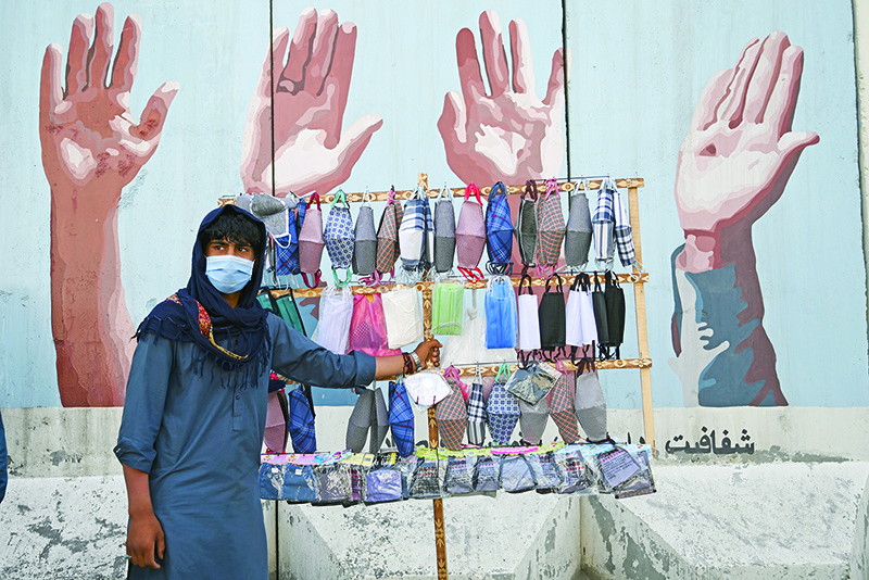 KABUL: A street vendor selling facemasks wait for customers in Kabul. — AFP