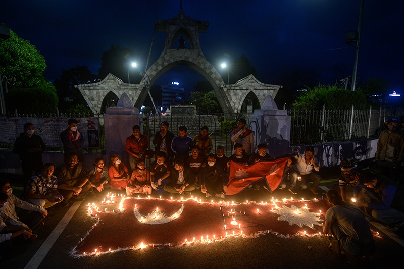 KATHMANDU: People light candles as they celebrate after the parliament approved a new national emblem with a controversial political map that includes strategic territories disputed with its giant neighbor India, in Kathmandu.—AFP