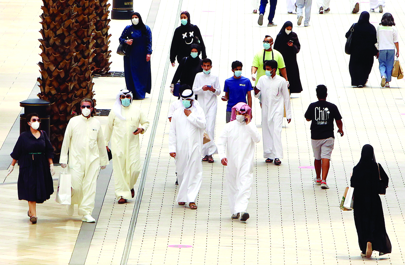 Kuwaitis wearing face masks walk inside the re-opened Avenues Mall, the country's largest shopping centre, on June 30, 2020 in Kuwait City after almost a four-months shutdown to prevent the spread of the coronavirus Covid-19 in the country. (Photo by YASSER AL-ZAYYAT / AFP)