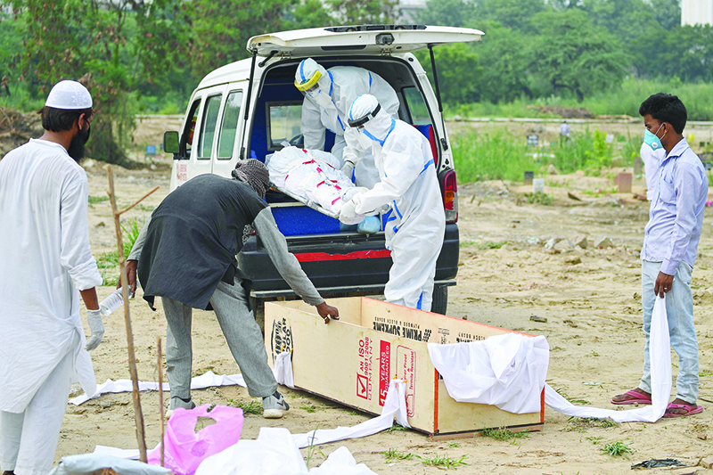 NEW DELHI: Health workers wearing protective gear carry the dead body of a victim, who died from the COVID-19 coronavirus, before the burial at a graveyard in New Delhi. — AFP