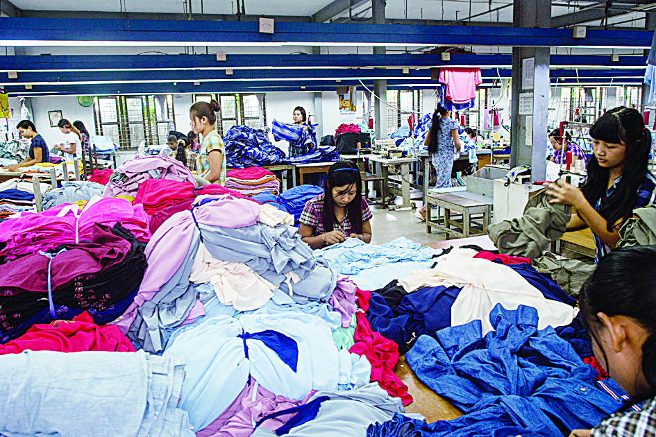 (FILES) In this file photo taken on November 1, 2018, workers work at a garment factory in Yangon. - From factory floors in India to the warehouses of Cambodia, garment workers for global brands say the collapse in demand triggered by coronavirus is being used as a cover to break their unions. (Photo by Ye Aung THU / AFP)