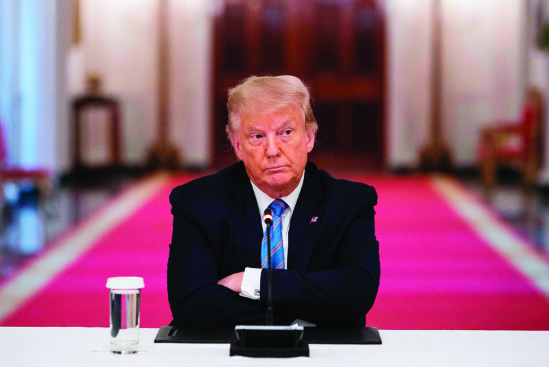 TOPSHOT - US President Donald Trump sits with his arms crossed during a roundtable discussion on the Safe Reopening of Americaís Schools during the coronavirus pandemic, in the East Room of the White House on July 7, 2020, in Washington, DC. (Photo by JIM WATSON / AFP)