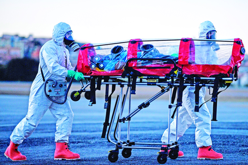 Members of the Military Firefighter Brigate of Minas Gerais (CBMMG) wearing protective gear, demonstrate the use of an isolation stretcher, or  bubble stretcher, to transport patients infected with coronavirus (COVID-19), at Pampulha Airport, in Belo Horizonte, state of Minas Gerais, Brazil, on July 22, 2020. - The equipment, which can be used to transport patients in aircrafts and ambulances, filters the air that the patient exhales in addition to isolating him. (Photo by DOUGLAS MAGNO / AFP)