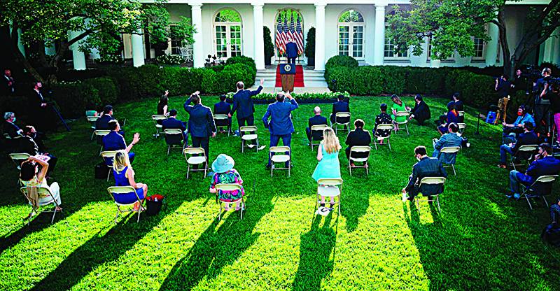 WASHINGTON: Members of the media, seated at a distance from one another, gesture toward the US President Donald Trump as he walks away from the podium after delivering a press conference in the Rose Garden of the White House. —AFP