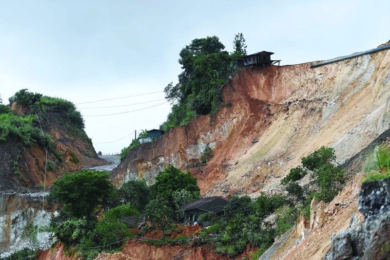 Damaged houses are seen next to the site of a deadly landslide in an area where miners work in open-cast jade mines near Hpakant in Kachin state on July 4, 2020. - Dozens of jade miners have been buried in a mass grave after a landslide in northern Myanmar killed over 170, most of them migrant workers seeking their fortune in treacherous open-cast mines near the China border. (Photo by Ye Aung Thu / AFP)