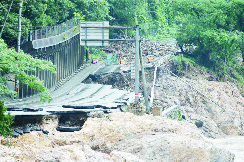 TOPSHOT - A road is destroyed following torrential rain near the Kuma river in Ashikita, Kumamoto prefecture, on July 6, 2020. - At least 37 people are feared dead after record rains lashed areas of western Japan, causing rivers to break banks and flooding low-lying regions. (Photo by STR / JIJI PRESS / AFP) / Japan OUT