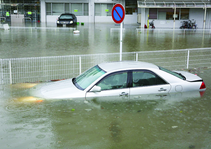 A car is submerged in floodwaters following a torrential rain in Kurume, Fukuoka prefecture on July 7, 2020. - Around 50 people were feared dead after heavy rain lashed areas of western Japan from early July 4, causing rivers to burst their banks and flood low-lying regions. (Photo by STR / JIJI PRESS / AFP) / Japan OUT