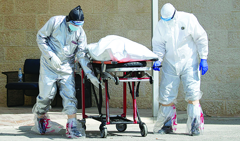 A Palestinian medical team transports the body of person who died of the COVID-19 disease from the military hospital in the West Bank city of Nablus, on July 9, 2020. (Photo by JAAFAR ASHTIYEH / AFP)