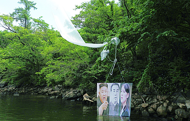 A balloon carrying a banner with portraits of North Korean leader Kim Jong Un (L), the late leader Kim Il Sung (C) and Kim Yo Jong, sister of Kim Jong Un, is caught on a tree after being launched by activists  in Hongcheon on June 23, 2020. - Balloons carrying half a million anti-Pyongyang leaflets were launched near the border towards North Korea, a defector-led activist group said on June 23, with the issue raising tensions on the peninsula. (Photo by STR / YONHAP / AFP) / - South Korea OUT / REPUBLIC OF KOREA OUT  NO ARCHIVES  RESTRICTED TO SUBSCRIPTION USE